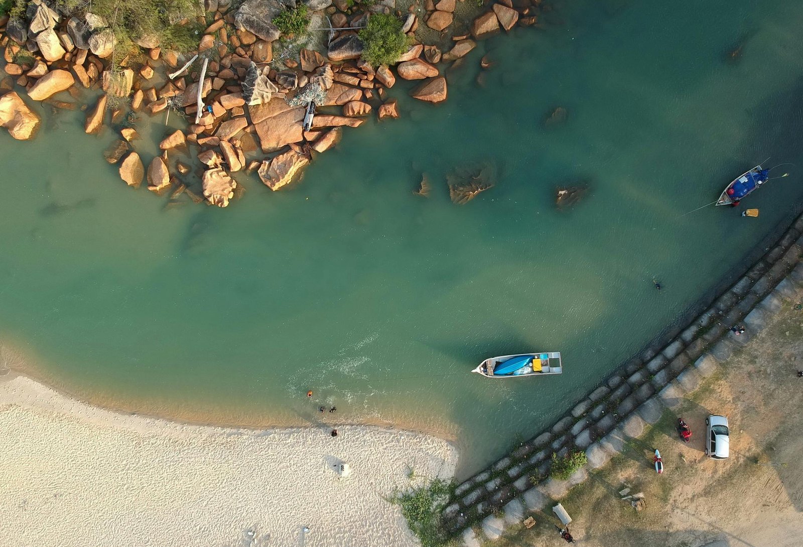Aerial view capturing boats and rocky shoreline at a serene beach in Kijal, Malaysia.